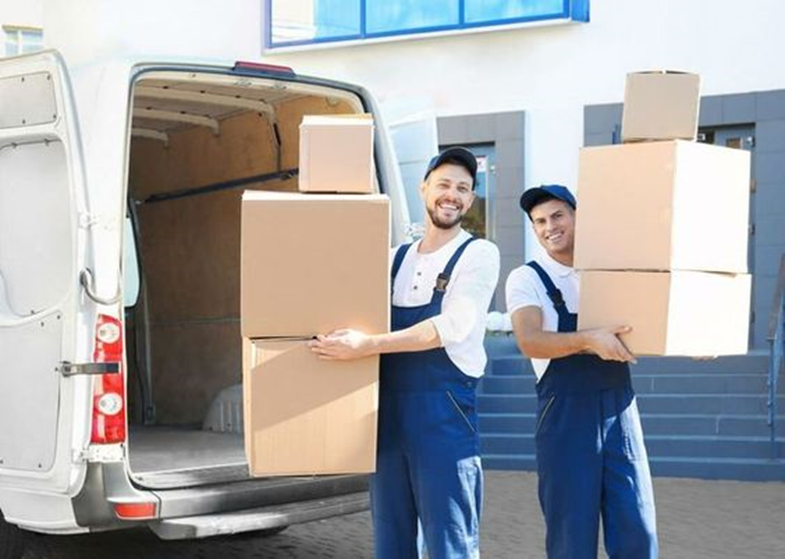 A group of movers and packers carefully wrapping and loading household items into moving boxes in Dubai. The team works efficiently, ensuring a smooth relocation process.